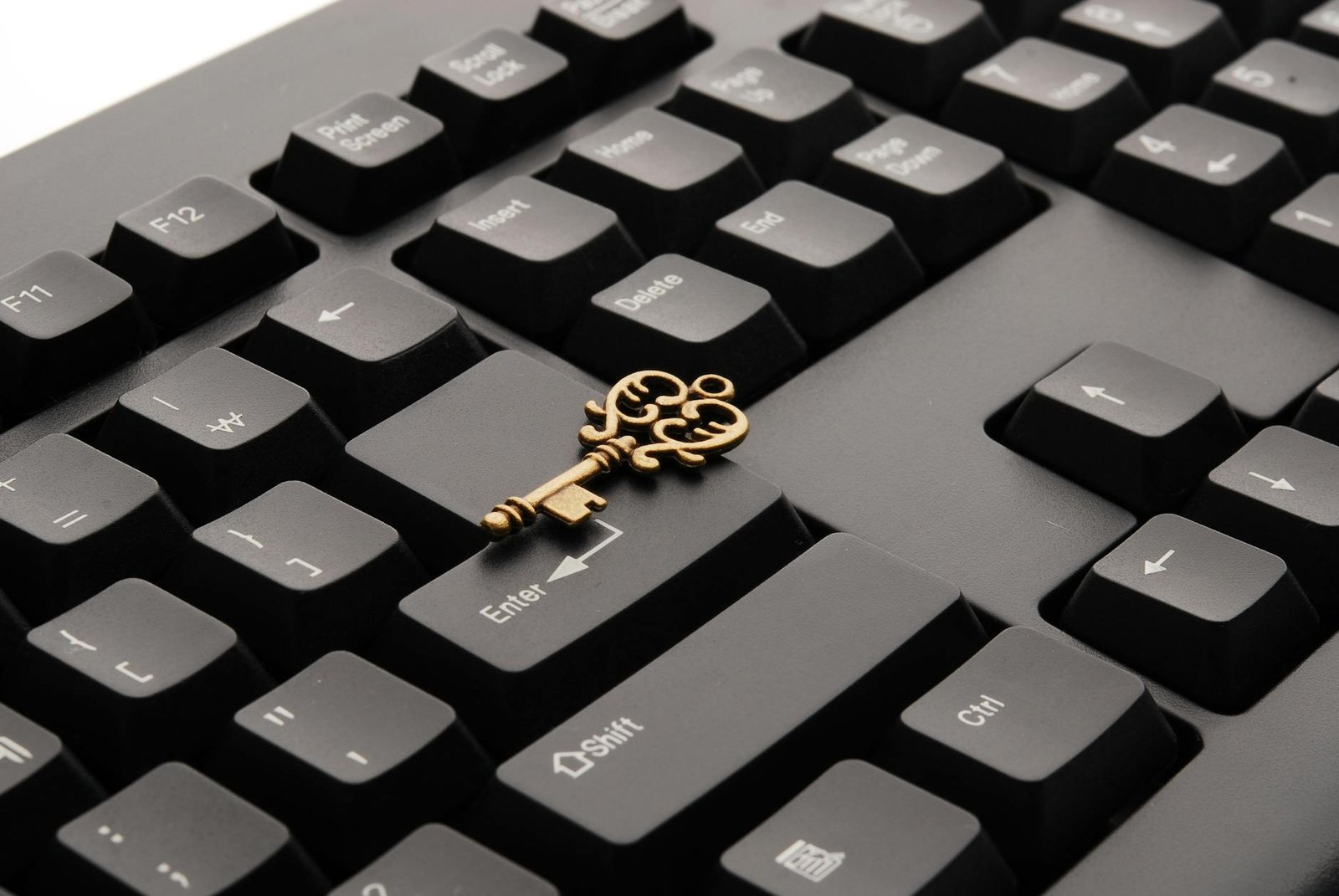 brass ornate vintage key on black computer keyboard